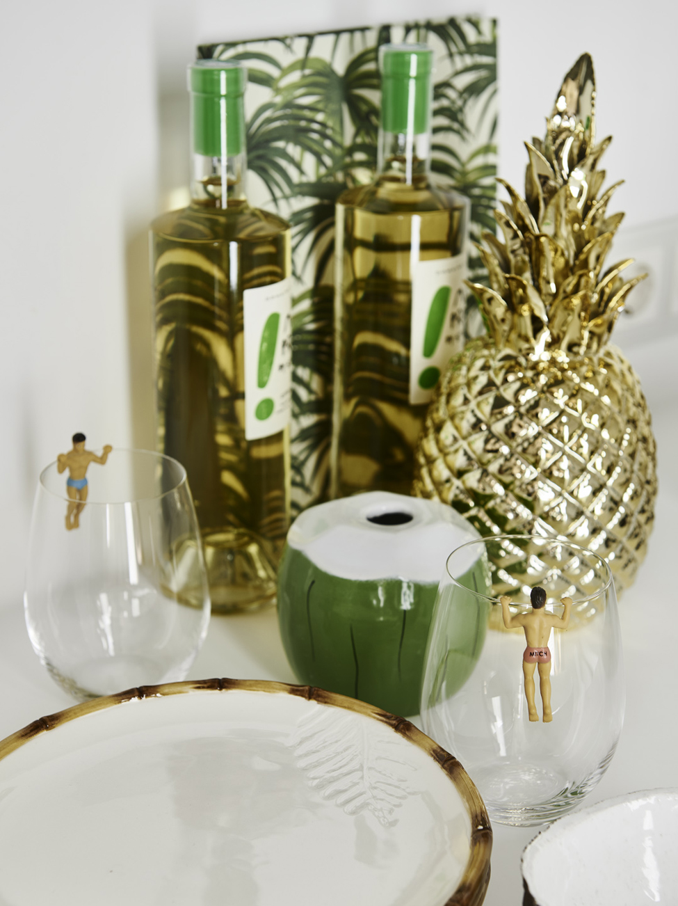 a golden pineapple, a ceramic coconut, bottles glasses and plates