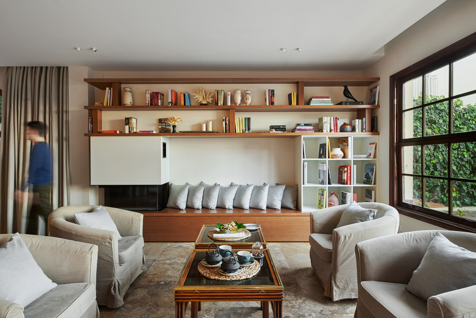 traditional living space with integrated firepit and bookshelves