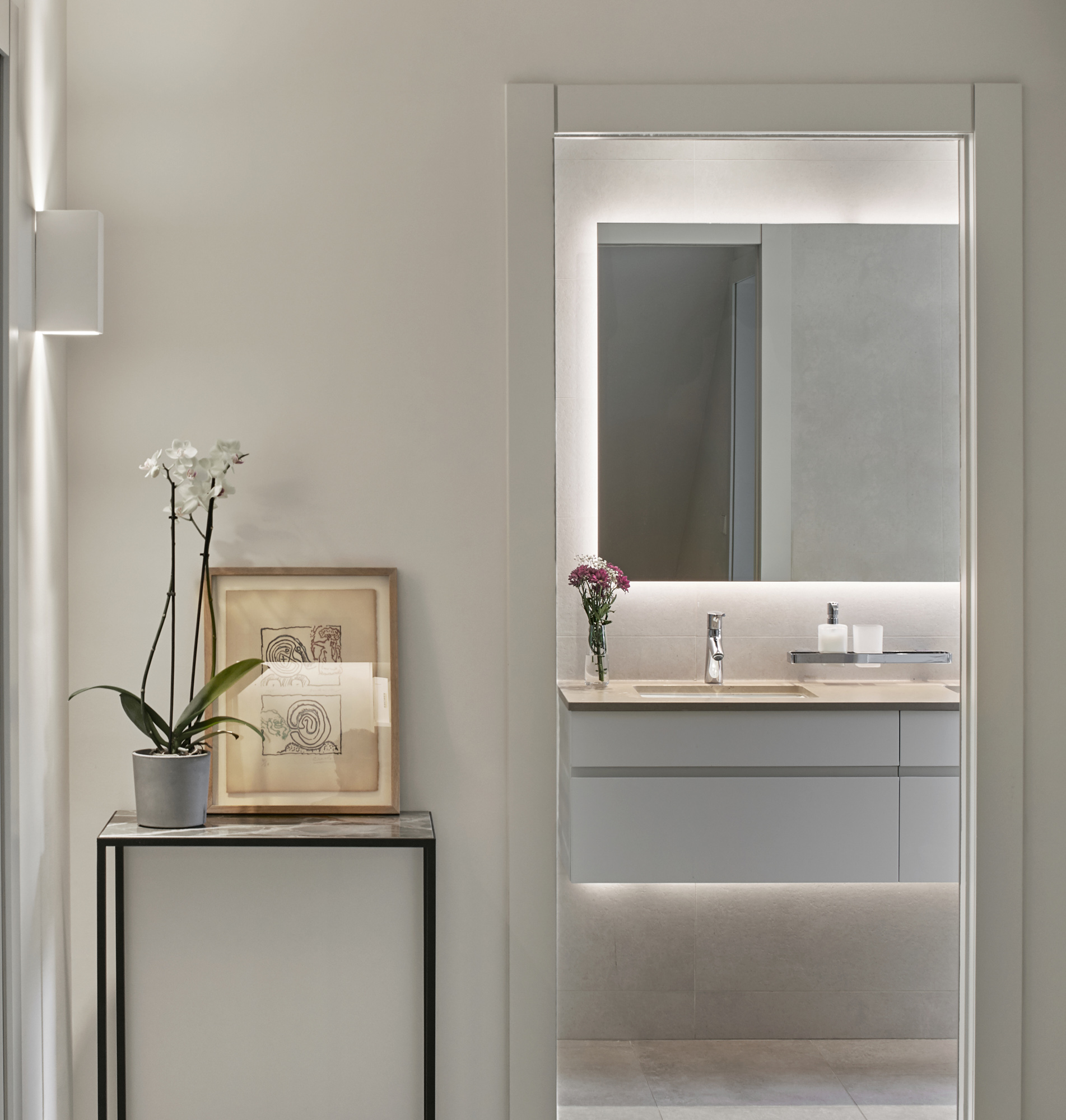 side table and view into minimalist bathroom through a open door